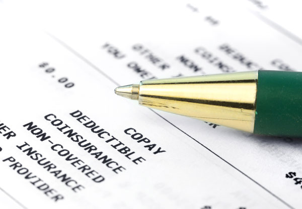 ink pen laying on an invoice indicating insurance contribution 